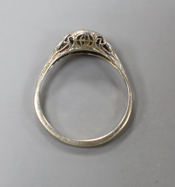 A white metal and collet set solitaire diamond ring, size J, gross weight 1.3 grams.
